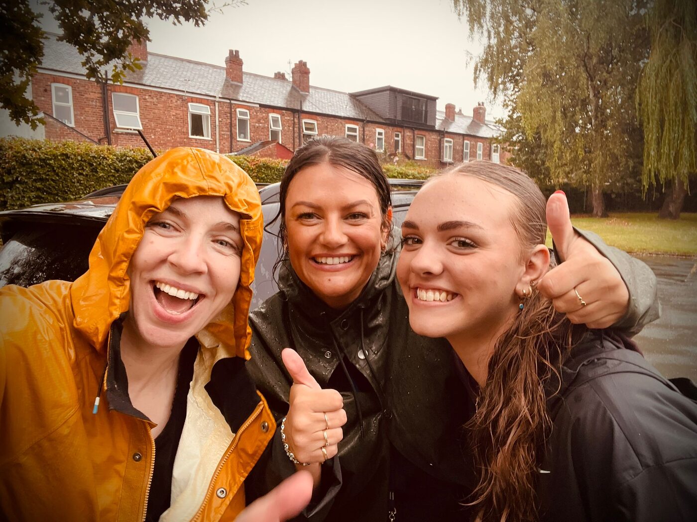 Liz, Emma and Amelie — the Love My Netball coaching team, soaked and smiling after the first session